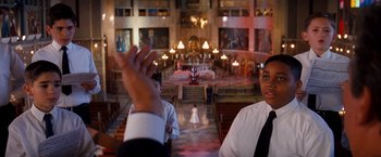 Movie still from “Romeo + Juliet” (1996), directed by Baz Luhrmann – Two people standing in front of an altar in a church; Medium shot, High angle