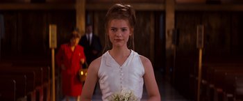 Movie still from “Romeo + Juliet” (1996), directed by Baz Luhrmann – A young woman in a white dress holding a bouquet of flowers; Close Up shot, Over the shoulder angle