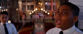 Movie still from “Romeo + Juliet” (1996), directed by Baz Luhrmann – A young boy in a white shirt is in a church; Close Up shot, Low angle