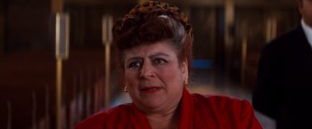 Movie still from “Romeo + Juliet” (1996), directed by Baz Luhrmann – An older woman wearing a red shirt and a leopard print hat; Close Up shot, Low angle