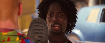 Movie still from “Romeo + Juliet” (1996), directed by Baz Luhrmann – A person holding a microphone; Close Up shot, Low angle