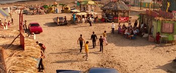Movie still from “Romeo + Juliet” (1996), directed by Baz Luhrmann – A group of people standing on top of a sandy beach; Extreme Wide shot, High angle