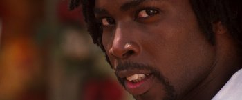 Movie still from “Romeo + Juliet” (1996), directed by Baz Luhrmann – A man's face with long black hair; Extreme Close Up shot, Low angle