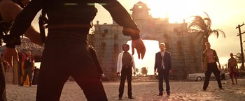 Movie still from “Romeo + Juliet” (1996), directed by Baz Luhrmann – Two men and a dog are standing in front of an old building; Wide shot, Low angle