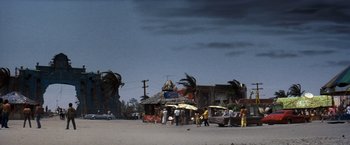 Movie still from “Romeo + Juliet” (1996), directed by Baz Luhrmann – A group of people standing on the side of a road; Extreme Wide shot, Low angle