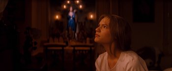 Movie still from “Romeo + Juliet” (1996), directed by Baz Luhrmann – A woman looking up into the air in front of candles; Medium shot, Low angle
