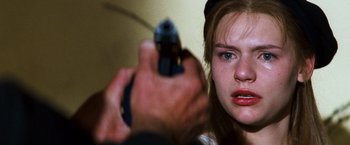 Movie still from “Romeo + Juliet” (1996), directed by Baz Luhrmann – A woman holding a gun pointed at the camera; Close Up shot, Over the shoulder angle