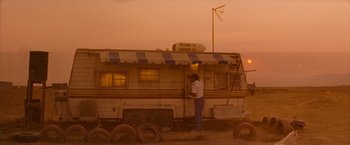 Movie still from “Romeo + Juliet” (1996), directed by Baz Luhrmann – A man standing in front of an old trailer; Extreme Wide shot, Low angle