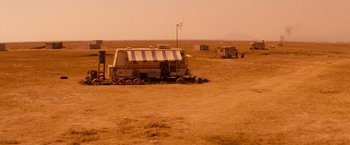 Movie still from “Romeo + Juliet” (1996), directed by Baz Luhrmann – An rv parked in the middle of a field; Extreme Wide shot, High angle