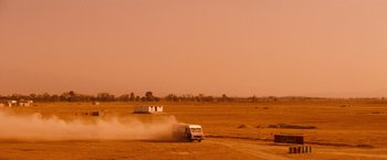 Movie still from “Romeo + Juliet” (1996), directed by Baz Luhrmann – A truck driving down a dirt road in the middle of a field; Extreme Wide shot, Low angle