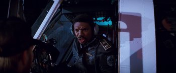 Movie still from “Romeo + Juliet” (1996), directed by Baz Luhrmann – A man in a black leather jacket is in the cockpit of a helicopter; Close Up shot, Overhead angle