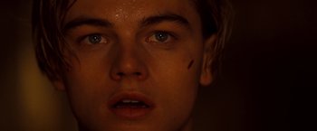 Movie still from “Romeo + Juliet” (1996), directed by Baz Luhrmann – A young man's face with a scar on his face; Close Up shot, Low angle