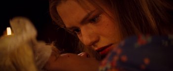 Movie still from “Romeo + Juliet” (1996), directed by Baz Luhrmann – A person holding a baby; Close Up shot, High angle