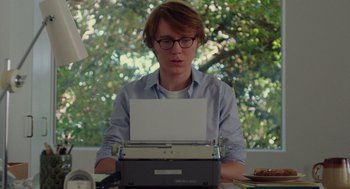 Movie still from “Ruby Sparks” (2012), directed by Valerie Faris – A person sitting at a table with a typewriter; Medium shot, Low angle
