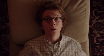 Movie still from “Ruby Sparks” (2012), directed by Valerie Faris – A man with glasses is laying on a bed; Close Up shot, Overhead angle