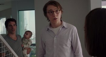 Movie still from “Ruby Sparks” (2012), directed by Valerie Faris – A man with glasses and a baby in a room; Medium shot, Over the shoulder angle