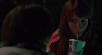Movie still from “Ruby Sparks” (2012), directed by Valerie Faris – A woman with red hair is drinking a beverage; Close Up shot, Over the shoulder angle