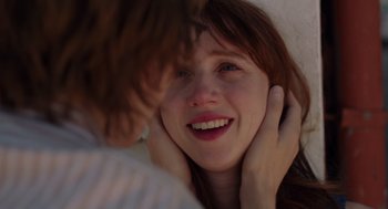 Movie still from “Ruby Sparks” (2012), directed by Valerie Faris – A young woman is smiling while holding her head; Close Up shot, Over the shoulder angle