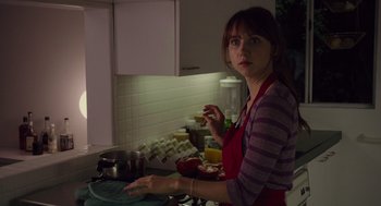 Movie still from “Ruby Sparks” (2012), directed by Valerie Faris – A woman in a kitchen preparing food on the counter; Medium shot, Over the shoulder angle