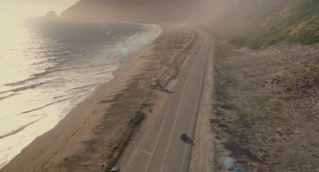 Movie still from “Ruby Sparks” (2012), directed by Valerie Faris – An aerial view of a road next to the ocean; Extreme Wide shot, High angle