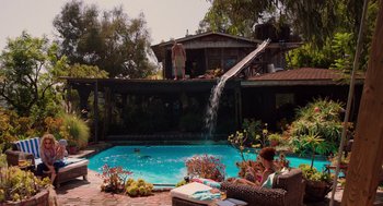 Movie still from “Ruby Sparks” (2012), directed by Valerie Faris – Two people in a backyard with a pool and a slide; Extreme Wide shot, High angle