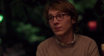 Movie still from “Ruby Sparks” (2012), directed by Valerie Faris – A man with glasses is sitting in front of a tree; Close Up shot, Over the shoulder angle