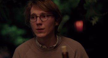 Movie still from “Ruby Sparks” (2012), directed by Valerie Faris – A man with glasses is holding a bottle of wine; Close Up shot, Over the shoulder angle