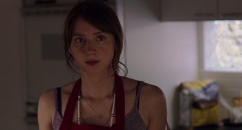 Movie still from “Ruby Sparks” (2012), directed by Valerie Faris – A woman wearing an apron in a kitchen; Close Up shot, Over the shoulder angle