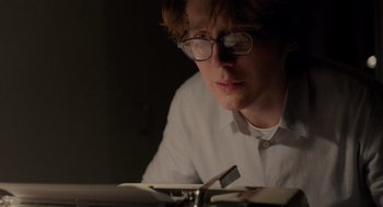 Movie still from “Ruby Sparks” (2012), directed by Valerie Faris – A man with glasses is reading a book in the dark; Close Up shot, Low angle