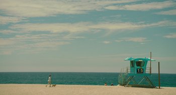 Movie still from “Ruby Sparks” (2012), directed by Valerie Faris – A man walking a dog on the beach near the ocean; Extreme Wide shot, High angle