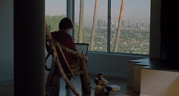 A person sitting in a chair looking out a large window