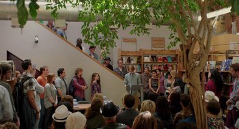 Movie still from “Ruby Sparks” (2012), directed by Valerie Faris – A group of people standing in a room with trees; Wide shot, High angle