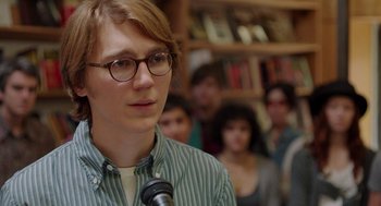 Movie still from “Ruby Sparks” (2012), directed by Valerie Faris – A man with glasses is speaking into a microphone; Close Up shot, Over the shoulder angle