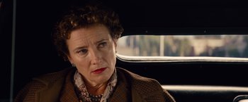 Movie still from “Saving Mr. Banks” (2013), directed by John Lee Hancock – An older woman in a brown jacket sitting in the back of a car; Close Up shot, Over the shoulder angle
