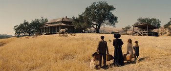 Movie still from “Saving Mr. Banks” (2013), directed by John Lee Hancock – A man and a woman holding suitcases in a field; Extreme Wide shot, Low angle