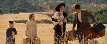Movie still from “Saving Mr. Banks” (2013), directed by John Lee Hancock – A group of people standing on top of a grass covered field; Wide shot, Over the shoulder angle