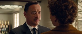 Movie still from “Saving Mr. Banks” (2013), directed by John Lee Hancock – A man in a suit and tie talking to a woman in a suit; Close Up shot, Over the shoulder angle