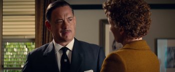 Movie still from “Saving Mr. Banks” (2013), directed by John Lee Hancock – A man in a suit talking to a woman in a yellow sweater; Close Up shot, Over the shoulder angle