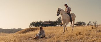 Movie still from “Saving Mr. Banks” (2013), directed by John Lee Hancock – A man and a woman riding a horse in a field; Wide shot, Low angle