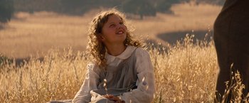 Movie still from “Saving Mr. Banks” (2013), directed by John Lee Hancock – A young girl sitting in a field of tall grass; Close Up shot, Low angle