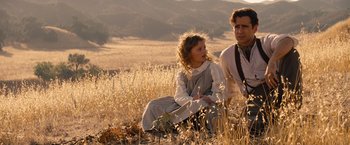 Movie still from “Saving Mr. Banks” (2013), directed by John Lee Hancock – A man and a woman sitting in a field of tall grass; Medium shot, Over the shoulder angle