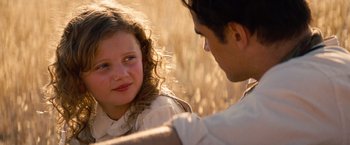 Movie still from “Saving Mr. Banks” (2013), directed by John Lee Hancock – A man and a girl sitting in a field talking to each other; Close Up shot, Over the shoulder angle
