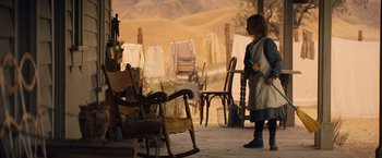 Movie still from “Saving Mr. Banks” (2013), directed by John Lee Hancock – A woman standing on a porch next to chairs; Wide shot, Over the shoulder angle