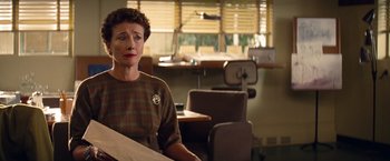 Movie still from “Saving Mr. Banks” (2013), directed by John Lee Hancock – An older woman sitting at a table in a room; Medium shot, Over the shoulder angle