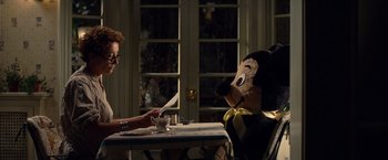 Movie still from “Saving Mr. Banks” (2013), directed by John Lee Hancock – A person sitting at a table with a stuffed animal; Medium shot, Over the shoulder angle