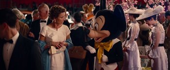 Movie still from “Saving Mr. Banks” (2013), directed by John Lee Hancock – A woman standing next to a mickey mouse character; Medium shot, Over the shoulder angle