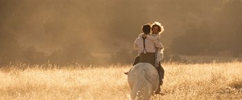 Movie still from “Saving Mr. Banks” (2013), directed by John Lee Hancock – A man and a woman riding a horse through a field; Wide shot, Low angle