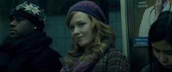 Movie still from “Shame” (2011), directed by Steve McQueen – A woman with a purple hat is smiling for the camera; Close Up shot, Over the shoulder angle