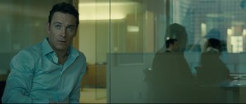 Movie still from “Shame” (2011), directed by Steve McQueen – A man standing in front of a glass wall; Medium shot, Over the shoulder angle