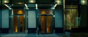 Movie still from “Shame” (2011), directed by Steve McQueen – A man walking on the sidewalk in front of a building; Wide shot, Low angle